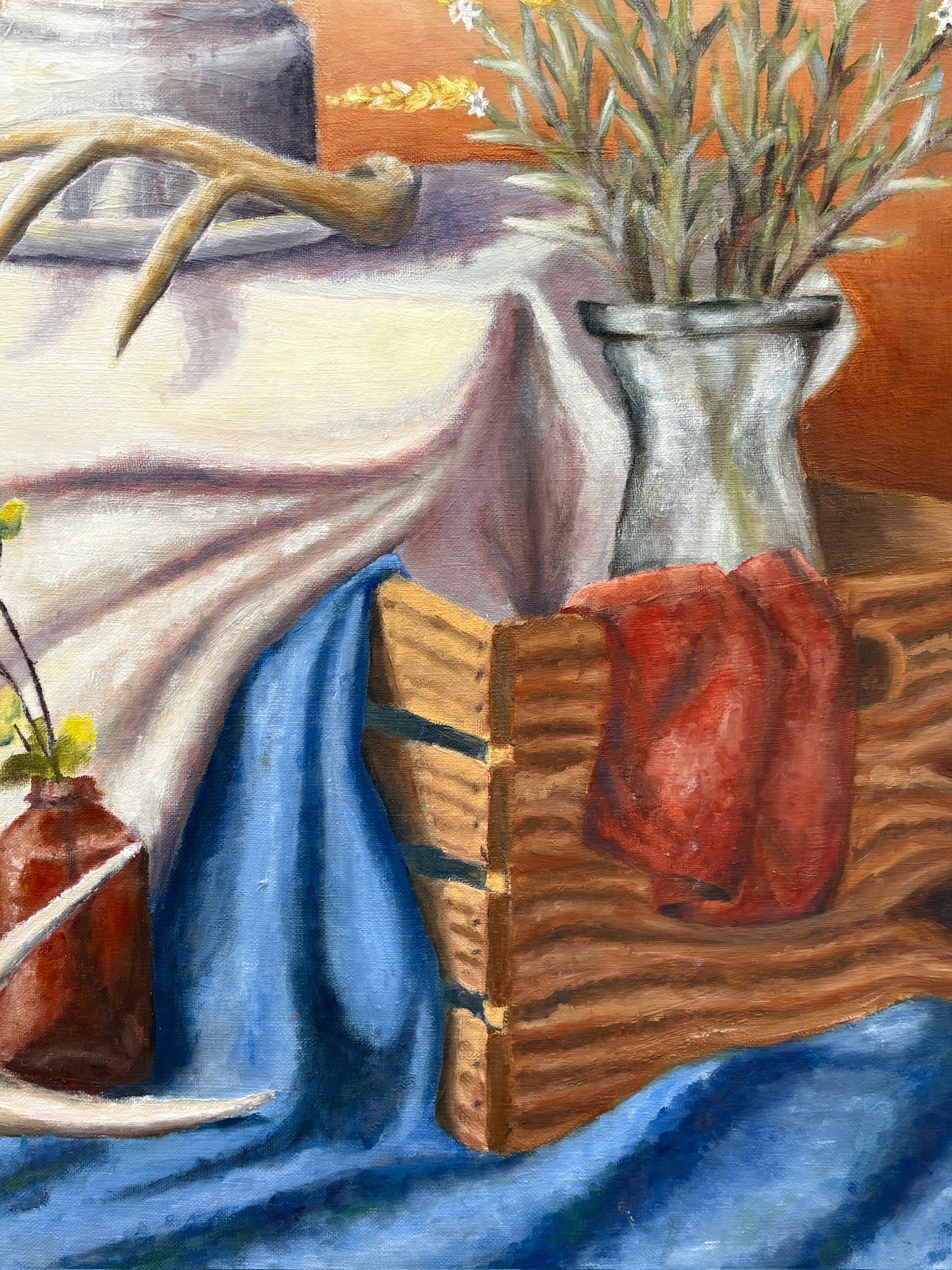 Oil painting still life with flowers, antlers, fabric, and a wooden box detail view